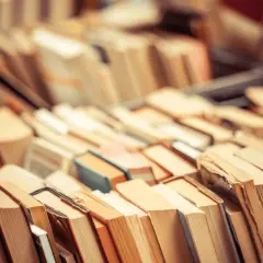 Stosy książek, które inspirują do zastanowienia, czy audiobooki zmieniają sposób, w jaki odbieramy świat przedstawiony.