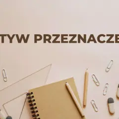 Notatnik, ołówki, linijka, gumki i spinacze na jasnym tle.
