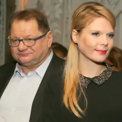 Mężczyzna w okularach i młoda kobieta w czarnej sukience z ozdobnym kołnierzykiem.