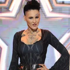 Chylińska, której wiek jest tajemnicą, w czarnej sukni z tatuażami na szyi i klatce piersiowej.
