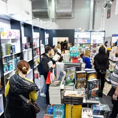 Ludzie na targach książki, gdzie prezentowane są najnowsze publikacje. To miejsce, gdzie można poczuć atmosferę najważniejszych targów książki na świecie dla branży wydawniczej.