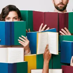 Ludzie czytają książki, odzwierciedlając jakie są trendy w literaturze faktu i reportażu wydawniczym 2026.