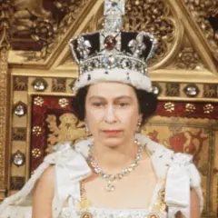 Królowa Elżbieta II w koronie i szacie, siedząca na tronie. Zastanawiamy się, ile żyła królowa Elżbieta, która panowała przez dekady.