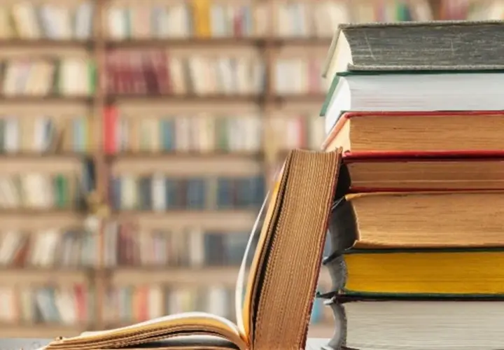 Stos książek na tle biblioteki. Unikaj chaosu w nazewnictwie zakładek w dużym projekcie literackim, by nie zgubić wątku.
