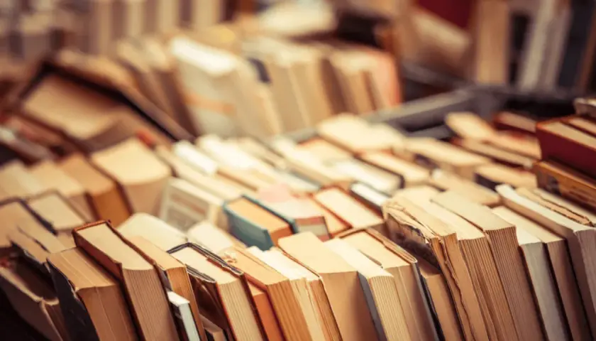 Stosy książek, które inspirują do zastanowienia, czy audiobooki zmieniają sposób, w jaki odbieramy świat przedstawiony.