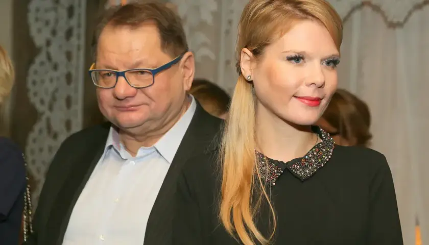 Mężczyzna w okularach i młoda kobieta w czarnej sukience z ozdobnym kołnierzykiem.