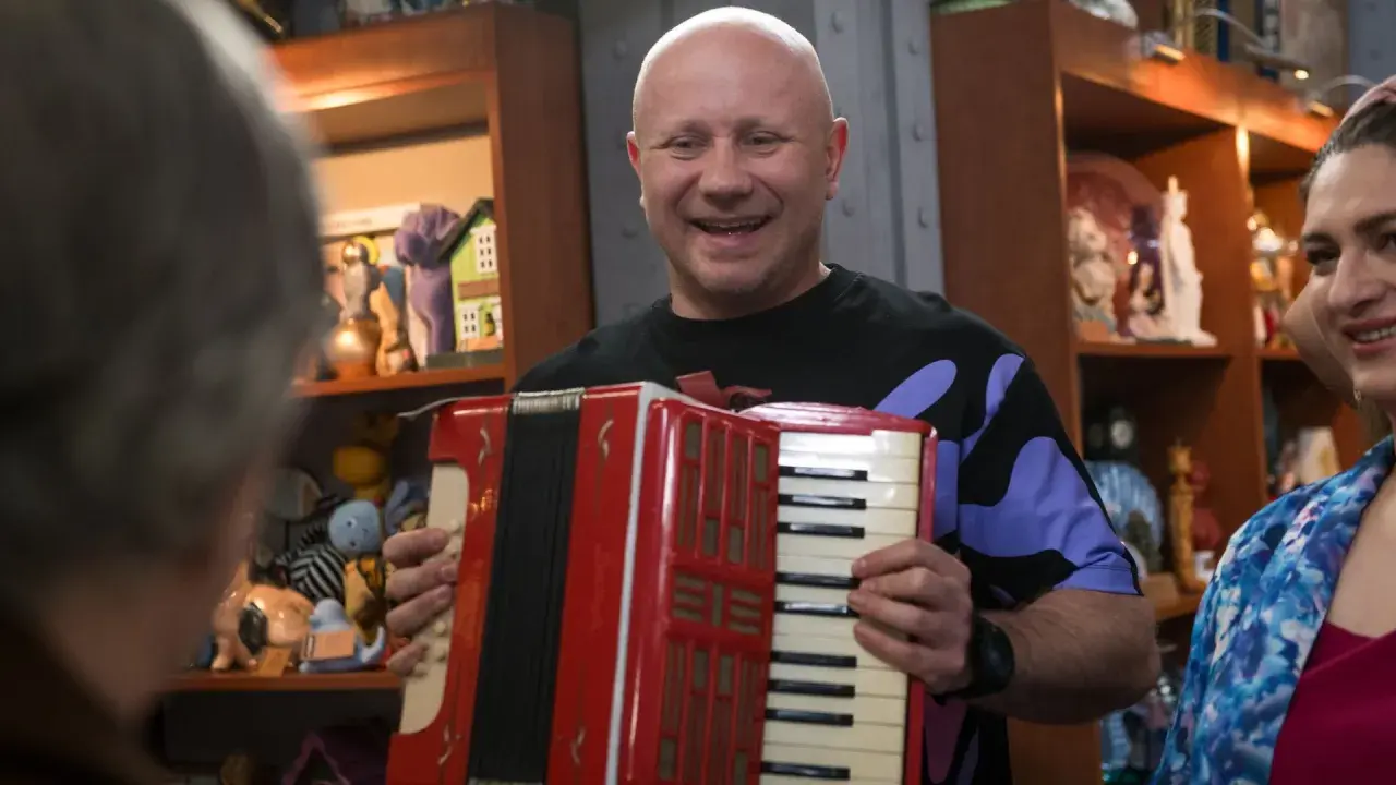 Mariusz z lombardu, grając na akordeonie, wygląda na szczęśliwego. Nie wiadomo, ile lat ma Mariusz z lombardu.