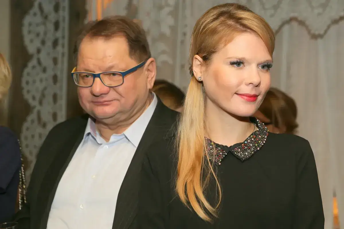 Mężczyzna w okularach i młoda kobieta w czarnej sukience z ozdobnym kołnierzykiem.
