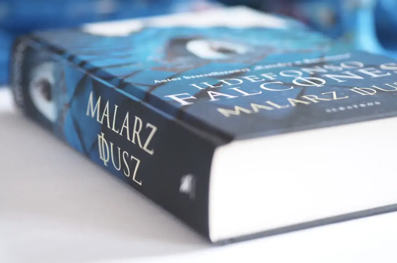 Okładka książki "Malarz dusz" Ildefonso Falconesa w odcieniach niebieskiego.