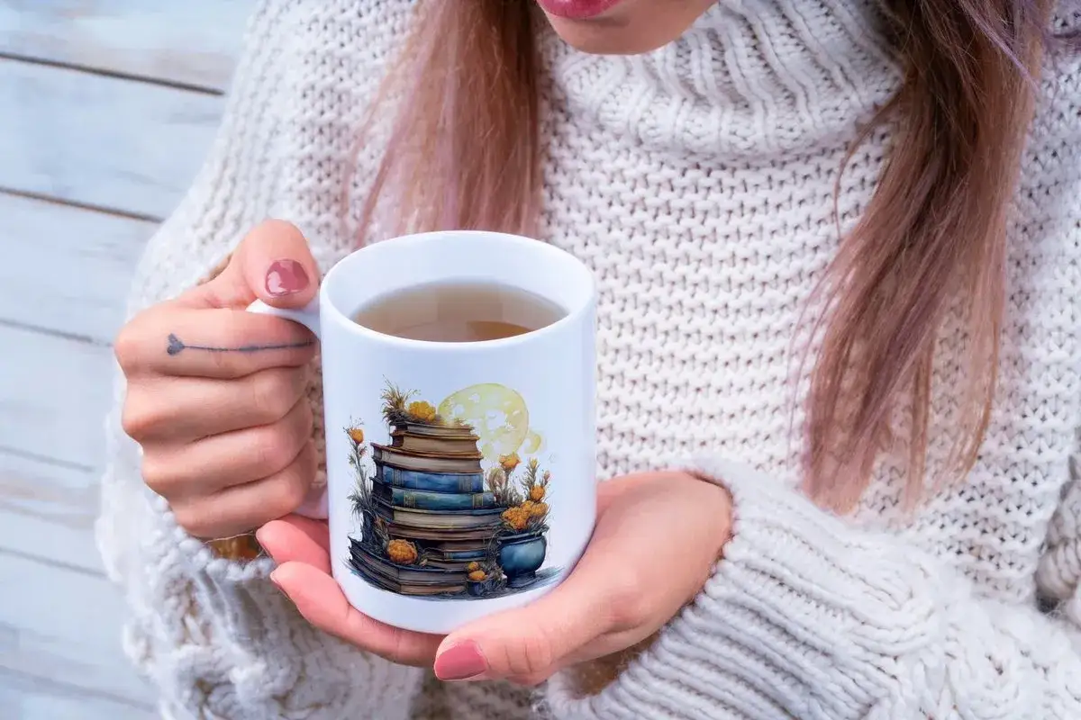 Kubek z ilustracją stosu książek i księżycem. Idealny dla fanów literatury